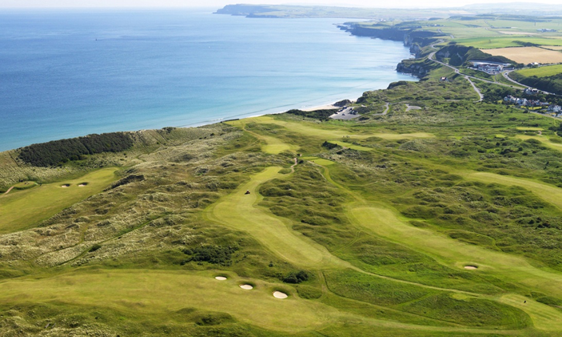 Golfspelare står stilla och tyst i bakgrunden medan en annan spelare puttar.